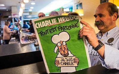 A man reads the latest edition of French satirical weekly Charlie Hebdo at a cafe in Dunkirk on January 14, 2015 shortly after the edition went on sale (photo credit: AFP/PHILIPPE HUGUEN) A man reads the latest edition of French satirical weekly Charlie Hebdo at a cafe in Dunkirk on January 14, 2015 shortly after the edition went on sale (photo credit: AFP/PHILIPPE HUGUEN)