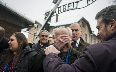 Holocaust survivor Mordechai Ronen is comforted by his son as he is overcome by emotion standing next to President of the World Jewish Congress Ronald Lauder, second right, as he arrives at the former Auschwitz concentration camp on January 26, 2015. photo credit: AFP/ODD ANDERSEN)