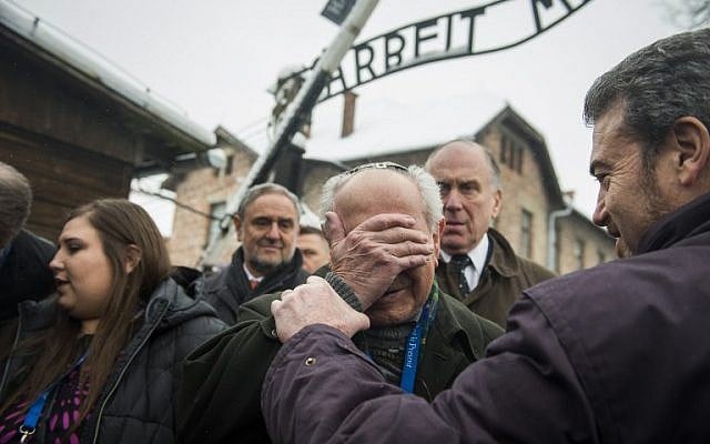 Holocaust survivor Mordechai Ronen, from the US, is comforted by his son as he is overcome by emotion standing next to President of the World Jewish Congress Ronald Lauder, second right, as he arrives at the former Auschwitz concentration camp on January 26, 2015. photo credit: AFP/ODD ANDERSEN)