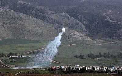 Smoke from Israeli shelling covers the Lebanese town of Al-Majidiyah (L) on the Lebanese border with Israel as the town of Al-Ghajar is seen on the right on January 28, 2015. (photo credit: Ali Dia/AFP) 
