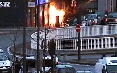 A screengrab taken from an AFP TV video shows a general view of members of the French police special forces launching the assault at a kosher grocery store in Porte de Vincennes, eastern Paris, on January 9, 2015 where at least two people were shot dead on January 9 during a hostage-taking drama at a Jewish supermarket in eastern Paris, and five people were being held, official sources told AFP. Several hostages were freed after French commandos stormed a Jewish supermarket in eastern Paris where an assailant was holed up on January 9. After several explosions, police stormed the shop in Portes de Vincennes and everal hostages exited the store shortly afterwards and were taken to safety. (pho credit: AFP/ AFPTV /Gabrielle Chatelain)