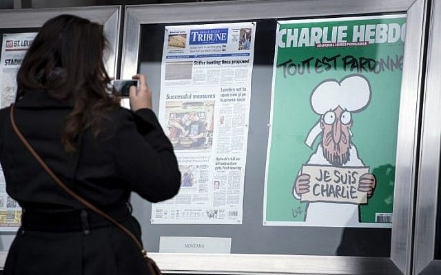 A woman takes a photo of the cover of the French satirical newspaper Charlie Hebdo featuring the Prophet Mohammed displayed with front pages for newspapers from around the world outside the Newseum January 14, 2015 in Washington, DC. (Photo credit: AFP PHOTO/BRENDAN SMIALOWSKI) A woman takes a photo of the cover of the French satirical newspaper Charlie Hebdo featuring the Prophet Mohammed displayed with front pages for newspapers from around the world outside the Newseum January 14, 2015 in Washington, DC. (Photo credit: AFP PHOTO/BRENDAN SMIALOWSKI)