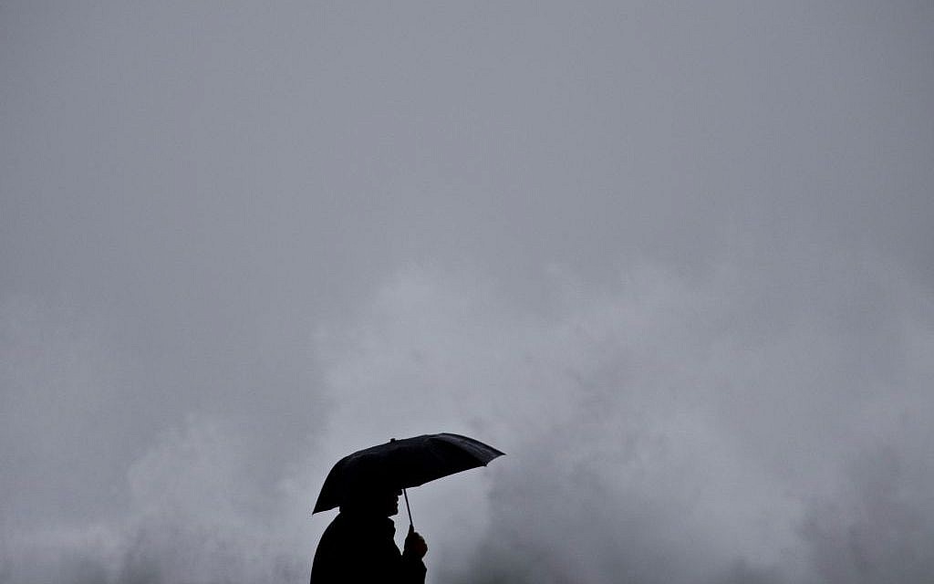 A person watches as waves crash on the Mediterranean sea near the port of Haifa, northern Israel, Tuesday, Jan. 6, 2015 (photo credit: AP/Ariel Schalit)