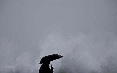A person watches as waves crash on the Mediterranean sea near the port of Haifa, northern Israel, Tuesday, Jan. 6, 2015 (photo credit: AP/Ariel Schalit)