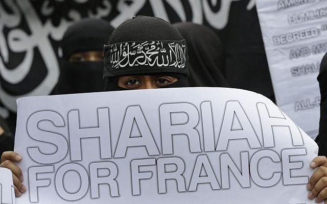 British Muslims hold placards as they demonstrate across the street from the French Embassy in London against the publication of caricatures of Islam's Prophet Muhammad by a French satirical weekly, Sept. 21, 2012 (photo credit: AP/Lefteris Pitarakis)