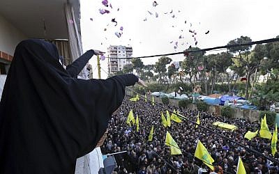 Lebanese women throw flowers on January 19, 2015 as Hezbollah supporters carry the coffin of Jihad Mughniyeh, the son of Imad Mughniyeh, who was killed in the air strike on the Syrian side of the Golan Heights (photo credit: AP/Bilal Hussein)