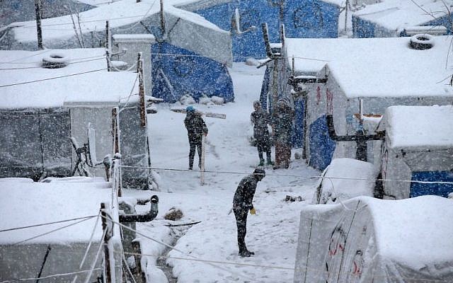 Syrians stand between their tents as they prepare to remove the snow from the top of their tents at a refugee camp in Deir Zannoun village, in the Bekaa valley, east Lebanon, Wednesday, Jan. 7, 2015. (Photo credit: AP/Hussein Malla) Syrians stand between their tents as they prepare to remove the snow from the top of their tents at a refugee camp in Deir Zannoun village, in the Bekaa valley, east Lebanon, Wednesday, Jan. 7, 2015. (Photo credit: AP/Hussein Malla)