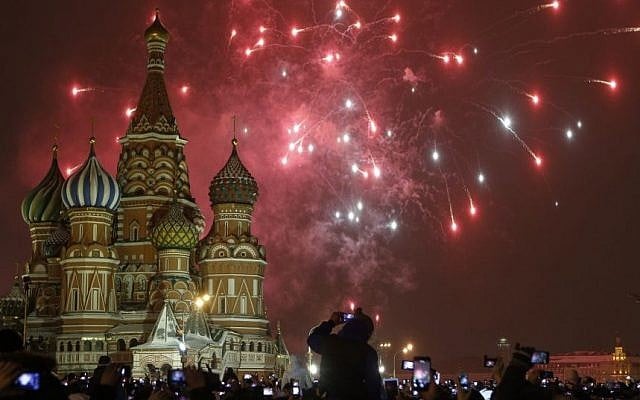 People photograph fireworks as they celebrate the New Year in Red Square in Moscow, Russia, Thursday, Jan. 1, 2015. (Photo credit: AP/Denis Tyrin)