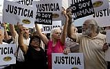 People gather outside the AMIA Jewish community center asking for "Justice" in the death of a prosecutor who had accused Argentina’s president of a criminal conspiracy, in Buenos Aires, Argentina, Wednesday, Jan. 21, 2015. (photo credit: AP Photo/Rodrigo Abd)
