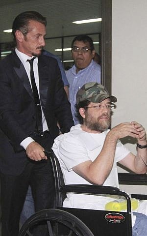  In this Dec. 11, 2012 file photo, actor Sean Penn pushes US businessman Jacob Ostreicher in a wheelchair, during a recess at Ostreicher's hearing in Santa Cruz, Bolivia.(photo credit: AP Photo, File)