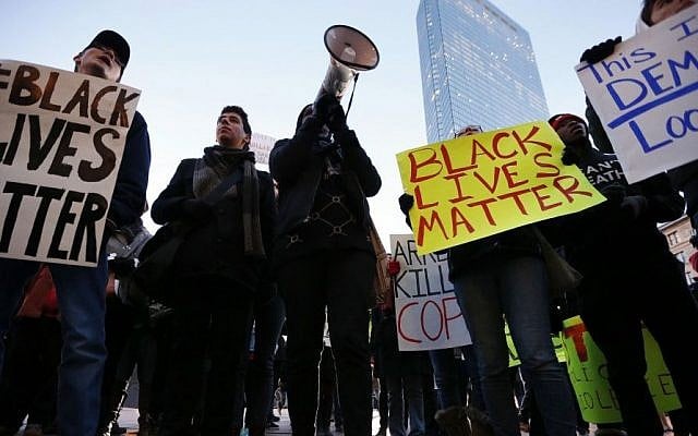 Demonstrators gather to protest recent police killings of unarmed black men during New Year's Eve celebrations in Copley Square in Boston, Wednesday, Dec. 31, 2014. (Photo credit: AP/Michael Dwyer)