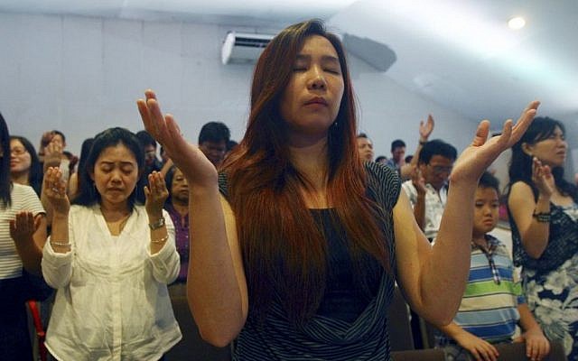 Members of Mawar Sharon church attend a prayer service for the relatives of lost loved ones aboard the AirAsia Flight 8501, in Surabaya, East Java, Indonesia Sunday, Jan. 4, 2015. About 40 members of the church were aboard the plane which crashed into the Java Sea a week ago. (Photo credit: AP/Firdia Lisnawati) Members of Mawar Sharon church attend a prayer service for the relatives of lost loved ones aboard the AirAsia Flight 8501, in Surabaya, East Java, Indonesia Sunday, Jan. 4, 2015. About 40 members of the church were aboard the plane which crashed into the Java Sea a week ago. (Photo credit: AP/Firdia Lisnawati)