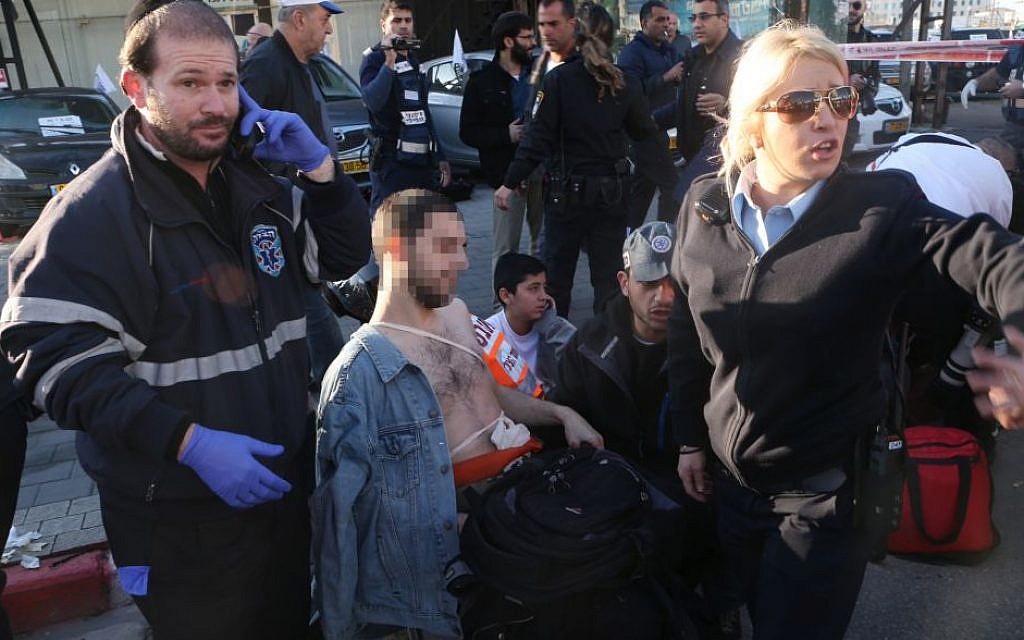 Medics and police evacuate a man injured in a stabbing attack on the No. 40 Dan bus in Tel Aviv on January 21, 2015. (photo credit: Flash90)