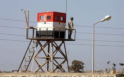 A picture taken from the Palestinian side of the Rafah border crossing in the southern Gaza Strip shows an Egyptian soldier manning a watch tower on the Egyptian side, on October 26, 2014. (photo credit: Abed Rahim Khatib/Flash90)