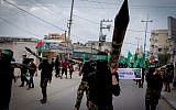 Illustrative: Masked Hamas members carry a model of a rocket during a rally in the central Gaza Strip on December 12, 2014. (Abed Rahim Khatib/Flash90)