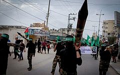 Illustrative: Masked Hamas members carry a model of a rocket during a rally in the central Gaza Strip on December 12, 2014. (Abed Rahim Khatib/Flash90)