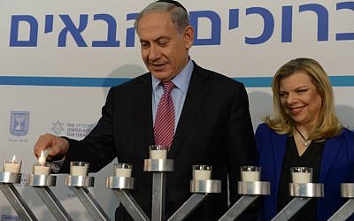 Too much? An article attacks Sara Netanyahu for being mean to house staff. In this photo Benjamin and Sara Netanyahu light candles during the Jewish holiday of Hanukkah in December 2014. (photo credit; Amos Ben Gershon/GPO)