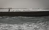 A fisherman walks along the pier in Tel Aviv on a stormy winter day on January 2, 2014. (photo credit: Hadas Parush/Flash90)
