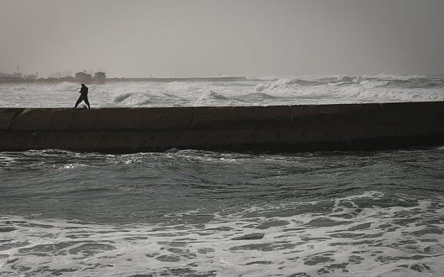 A fisherman walks along the pier in Tel Aviv on a stormy winter day on January 2, 2014. (photo credit: Hadas Parush/Flash90) A fisherman walks along the pier in Tel Aviv on a stormy winter day on January 2, 2014. (photo credit: Hadas Parush/Flash90)