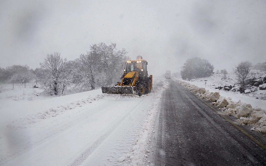 A backhoe plows a snow-covered road in the Golan Heights, northern Israel, Wednesday, January 7, 2015 (photo credit: Basal Awidat/FLASH90)