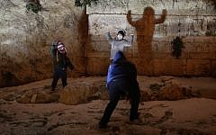 Children play near the walls of the Old City of Jerusalem as a heavy winter storm hit Israel, on January 7, 2015. (Photo credit: Nati Shohat/Flash90)