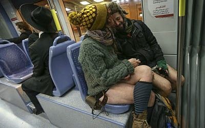 Helena and Bozo snuggle as they ride the Jerusalem light rail train in their underwear for No Pants Train Ride, January 11, 2015. (Nati Shohat/Flash 90)