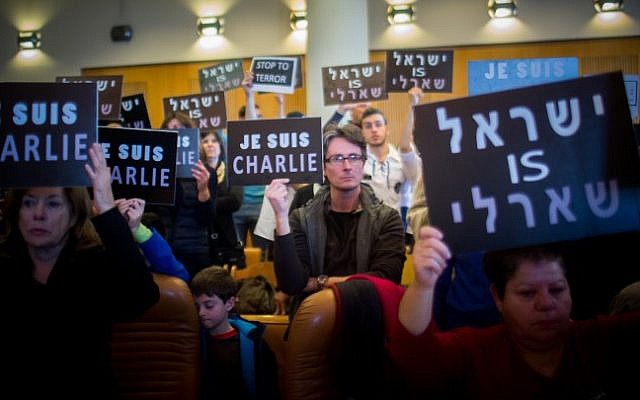 People hold placards during a remembrance ceremony in Jerusalem City Hall on January 11, 2015, in honor of the 17 victims of the three-day Islamist killing spree in Paris. The Hebrew sign (R) reads "Israel is Charlie" (photo credit: Yonatan Sindel/Flash90) People hold placards during a remembrance ceremony in Jerusalem City Hall on January 11, 2015, in honor of the 17 victims of the three-day Islamist killing spree in Paris. The Hebrew sign (R) reads "Israel is Charlie" (photo credit: Yonatan Sindel/Flash90)