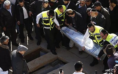 Mourners seen carrying one of the bodies for burial during the funeral ceremony of the four Jewish victims of the Paris kosher grocery attack that was held at Har HaMenuchot cemetery in Jerusalem, on January 13, 2015. (photo credit: Yonatan Sindel/Flash90)