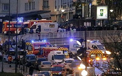 Police officers and rescue workers gather after police stormed a kosher grocery store where a gunman held several hostages, in Paris, Friday Jan. 9, 2015. (photo credit: AP Photo/Francois Mori) Police officers and rescue workers gather after police stormed a kosher grocery store where a gunman held several hostages, in Paris, Friday Jan. 9, 2015. (photo credit: AP Photo/Francois Mori)