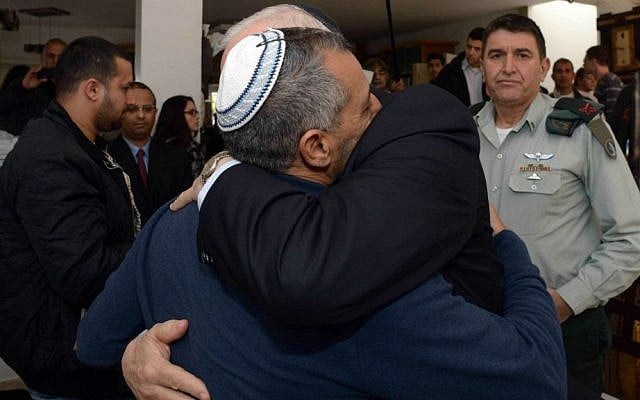 President Reuven Rivlin embracing the father of Staff Sargeant Dor Chaim Nini in Shtulim on January 30, 2015. Nini was killed in action after his convoy was struck by a Hezbollah anti-tank round on Mount Dov. (photo credit: Haim Zach/GPO)