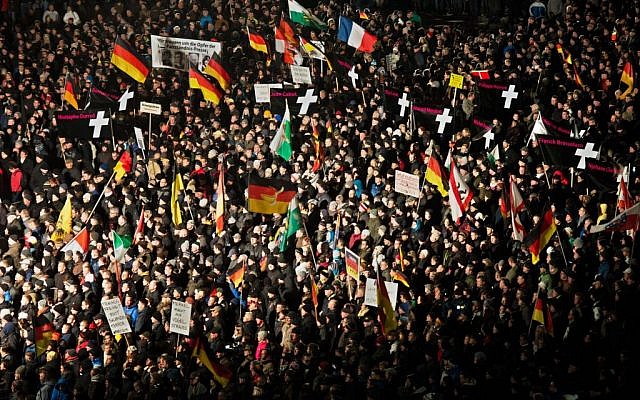 Demonstrators hold signs with the victims of the Paris terror attack during a rally of the group Patriotic Europeans against the Islamization of the West, or PEGIDA in Dresden, eastern Germany, Monday, Jan 12, 2015. (photo credit: AP/dpa, Arno Burgi)