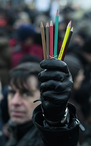 A man holds pencils as he gathers with several thousand people in solidarity with victims of two terrorist attacks in Paris, as he participates in a demonstration in front of the Brandenburg Gate near the French embassy in Berlin, Sunday, Jan. 11, 2015. (photo credit: AP/Markus Schreiber) 