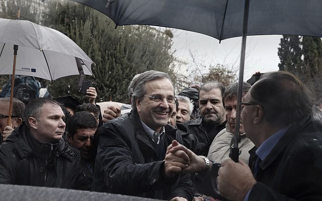 Supporters congratulate Greece's Prime Minister Antonis Samaras, center, outside an election kiosk of his conservative New Democracy party, in Athens, Saturday, Jan. 24, 2015 (photo credit: AP/Petros Giannakouris)