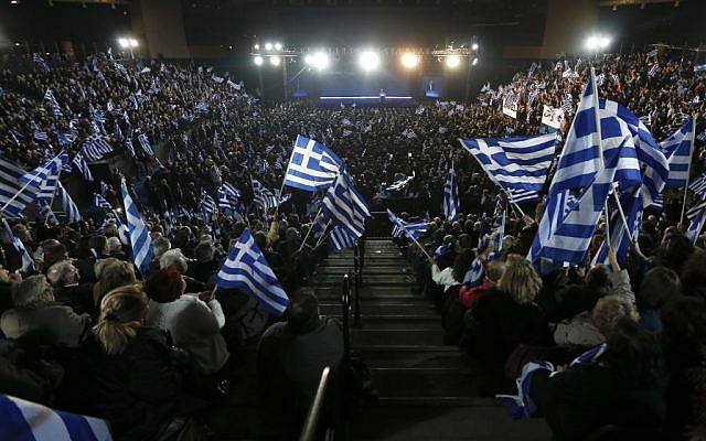 Supporters of Greece's Prime Minister Antonis Samaras wave Greek flags during his final campaign speech at the Taekwondo Indoor Stadium in southern Athens on Friday, Jan. 23, 2015 (photo credit: AP/Petros Giannakouris)