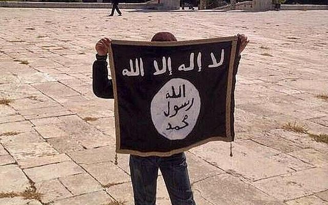Illustrative photo of a teen holding an Islamic State flag on the Temple Mount in Jerusalem in August 2014. (Facebook) Illustrative photo of a teen holding an Islamic State flag on the Temple Mount in Jerusalem in August 2014. (Facebook)
