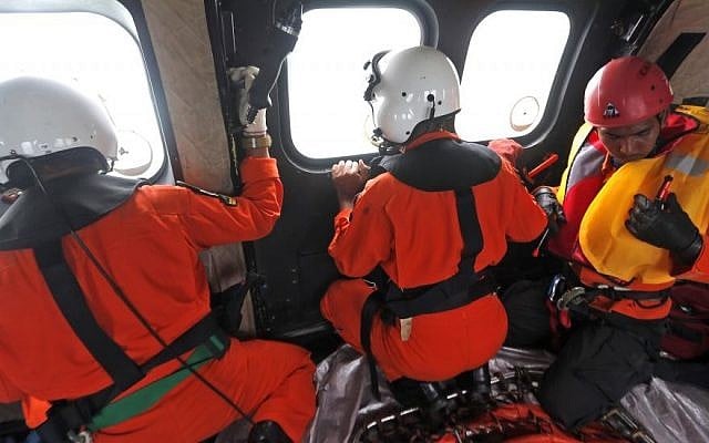 Crew members of Indonesian Air Force NAS 332 Super Puma helicopter look out of the windows during a search operation for the victims of AirAsia Flight 8501 over the Java Sea, Indonesia, Sunday, Jan. 4, 2015. (Photo credit: AP/Adi Weda, Pool) Crew members of Indonesian Air Force NAS 332 Super Puma helicopter look out of the windows during a search operation for the victims of AirAsia Flight 8501 over the Java Sea, Indonesia, Sunday, Jan. 4, 2015. (Photo credit: AP/Adi Weda, Pool)