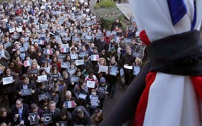 French residents and local Japanese hold 'Je suis Charlie' signs as they attend a special memorial gathering under a French national flag tied with a black ribbon at the French Institute in Tokyo, Japan, Sunday, Jan. 11, 2015 (photo credit: AP/Shizuo Kambayashi) 