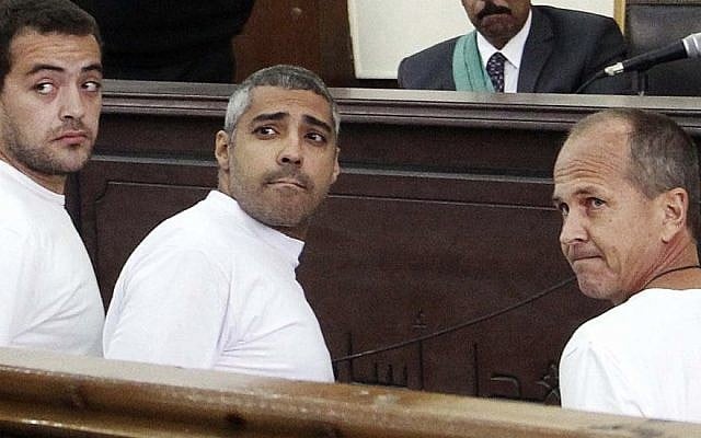 Al-Jazeera English producer Baher Mohamed (left), Canadian-Egyptian acting Cairo bureau chief Mohamed Fahmy (center), and correspondent Peter Greste (right), appear in court along with several other defendants during their trial on terror charges, in Cairo, Egypt, March 31, 2014. (photo credit: AP/Heba Elkholy, el Shorouk, File) Al-Jazeera English producer Baher Mohamed (left), Canadian-Egyptian acting Cairo bureau chief Mohamed Fahmy (center), and correspondent Peter Greste (right), appear in court along with several other defendants during their trial on terror charges, in Cairo, Egypt, March 31, 2014. (photo credit: AP/Heba Elkholy, el Shorouk, File)