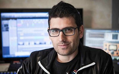 In this photo taken Tuesday, January 6, 2015, Israeli musician Noy Alooshe poses for a photograph in his studio in Tel Aviv, Israel. One of the most unlikely stars of Israel's election campaign is a musical artist whose popular video remixes of stump speeches have rocked YouTube. (photo credit: AP Photo/Dan Balilty)