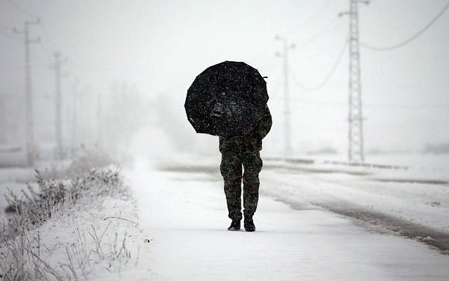 A Lebanese army soldier holds an umbrella as he walks at a main road covered by the snow, in Al-Marj village, in the Bekaa valley, east Lebanon, Wednesday, Jan. 7, 2015. While the storm disrupted life for everyone, it proved particularly trying for the hundreds of thousands of Syrian refugees who live in tents and makeshift shelters in the Bekaa. The storm dumped rain and hail on Lebanon’s coast and heavy snows in the mountains and central Bekaa Valley, where gas stations, banks, schools and most shops closed. (Photo credit: AP/Hussein Malla) A Lebanese army soldier holds an umbrella as he walks at a main road covered by the snow, in Al-Marj village, in the Bekaa valley, east Lebanon, Wednesday, Jan. 7, 2015. While the storm disrupted life for everyone, it proved particularly trying for the hundreds of thousands of Syrian refugees who live in tents and makeshift shelters in the Bekaa. The storm dumped rain and hail on Lebanon’s coast and heavy snows in the mountains and central Bekaa Valley, where gas stations, banks, schools and most shops closed. (Photo credit: AP/Hussein Malla)