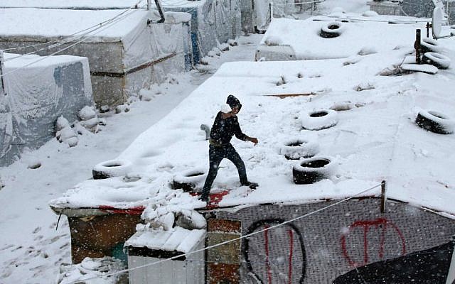 A Syrian boy throws snow from the top of his tent at a refugee camp in Deir Zannoun village, in the Bekaa valley, east Lebanon, Wednesday, Jan. 7, 2015. (Photo credit: AP/Hussein Malla) A Syrian boy throws snow from the top of his tent at a refugee camp in Deir Zannoun village, in the Bekaa valley, east Lebanon, Wednesday, Jan. 7, 2015. (Photo credit: AP/Hussein Malla)