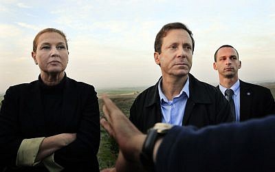 In this Thursday, Dec. 11, 2014 file photo, Israeli politicians Isaac Herzog, right, and Tzipi Livni listen during a tour along the Israel and Gaza Strip border.  (photo credit: AP Photo/Tsafrir Abayov, File )