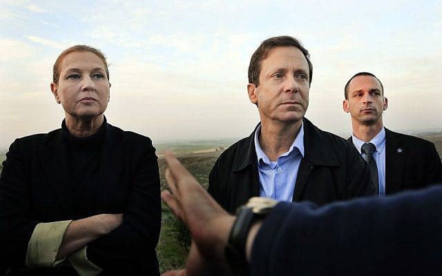 In this Thursday, Dec. 11, 2014 file photo, Israeli politicians Isaac Herzog, right, and Tzipi Livni listen during a tour along the Israel and Gaza Strip border.  (photo credit: AP Photo/Tsafrir Abayov, File )