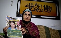 Khawla Al-Khatib, holds a poster of her imprisoned 14-year-old daughter, Malak, in the village of Beitin near Ramallah (Majdi Mohammed/AP Photo)