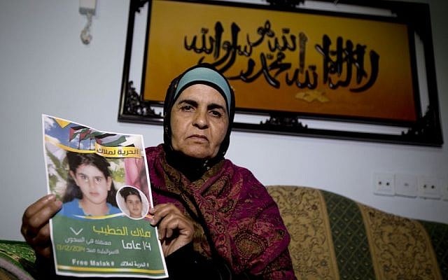 Khawla Al-Khatib, holds a poster of her imprisoned 14-year-old daughter, Malak, in the village of Beitin near Ramallah (Majdi Mohammed/AP Photo) Khawla Al-Khatib, holds a poster of her imprisoned 14-year-old daughter, Malak, in the village of Beitin near Ramallah (Majdi Mohammed/AP Photo)
