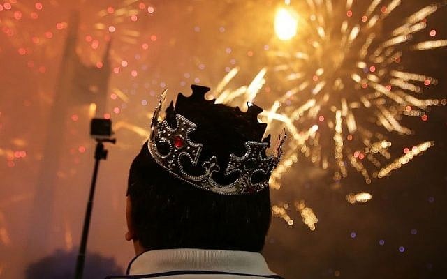 A Filipino watches a fireworks display at the Quezon Memorial Circle in suburban Quezon city, north of Manila, Philippines on Thursday, Jan. 1, 2015. (Photo credit: AP/Aaron Favila)