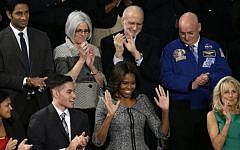First lady Michelle Obama acknowledges applause on Capitol Hill in Washington, Tuesday, Jan. 20, 2015, before President Barack Obama's State of the Union address before a joint session of Congress. Front row from left are, Astrid Muhammad, Anthony Mendez, Mrs. Obama, and Jill Biden. Second row, from left are, Pranav Shetty, Judy Gross, Alan Gross and Scott Kelly. (Photo credit: AP/Pablo Martinez Monsivais)