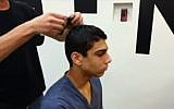 A young man gets fitted for his Magic Kippa. (YouTube screenshot)