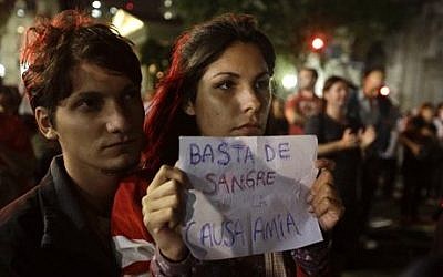 A protester holds a sign that reads in Spanish 'No more blood in the AMIA case' as people gather outside the government palace in Plaza de Mayo in response to the death of special prosecutor and AMIA bombing investigator Alberto Nisman in Buenos Aires, Argentina, Monday, January 19, 2015.  (photo credit: AP Photo/Victor R. Caivano)