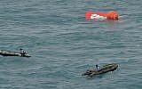 Portion of the tail of AirAsia Flight 8501 floats on the water as Indonesian navy divers conduct search operations for the black boxes of the crashed plane in the Java Sea, Indonesia, Saturday, Jan. 10, 2015 (photo credit: AP Photo/Adek Berry)
